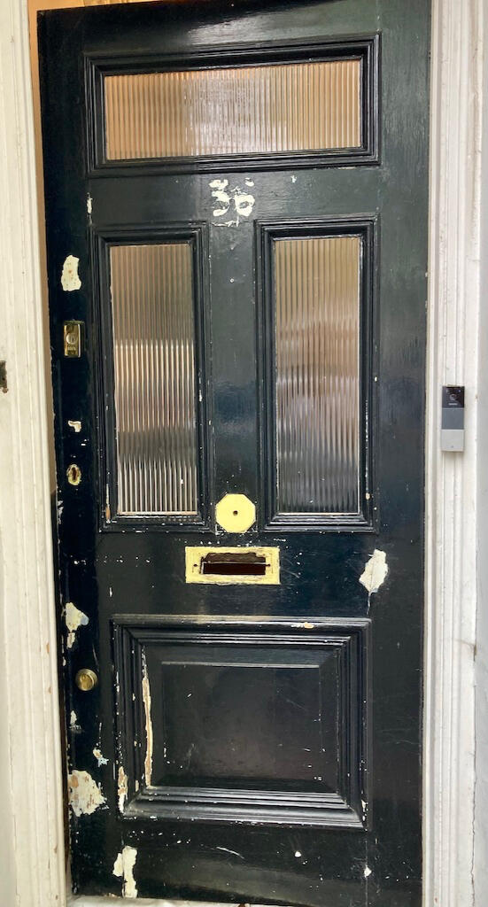 Front door before repainting and replacing hardware such as handle, letterbox, and house number