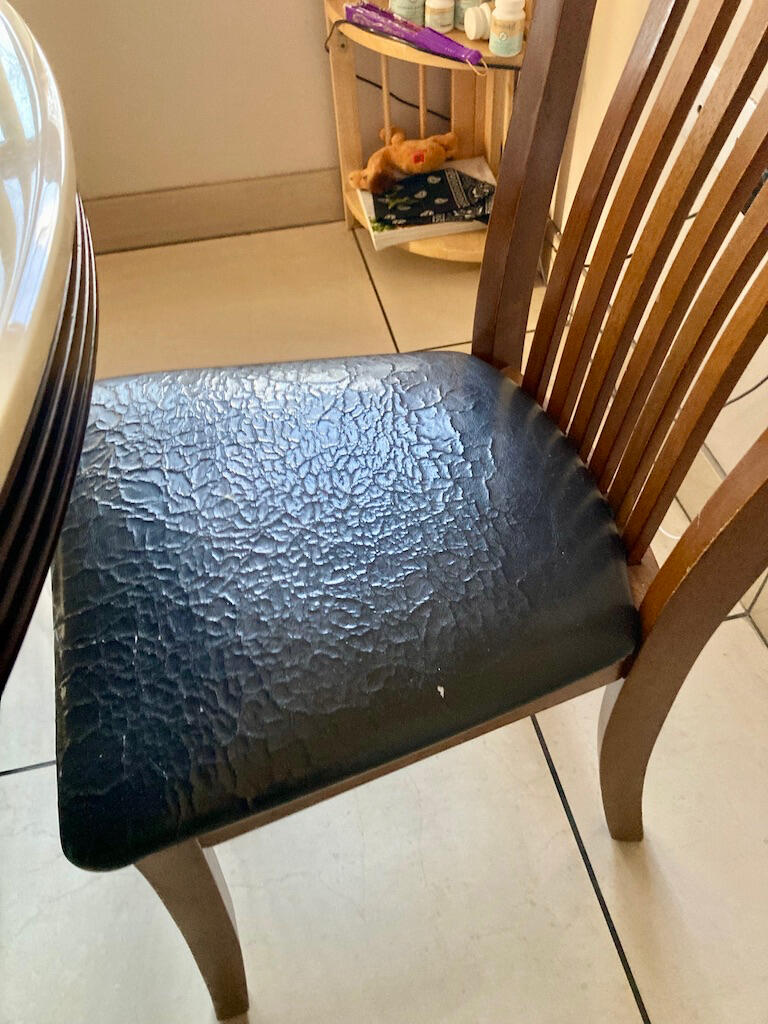 Old chair before reupholstery showing worn fabric & padding